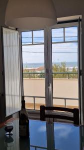 cocina con 2 ventanas y vistas al océano en Casa do Xixo, en Quiaios