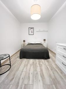 1 dormitorio con 1 cama y suelo de madera en 3 bedrooms with private parking By Canary365, en Las Palmas de Gran Canaria