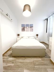 Dormitorio blanco con cama y lámpara en 3 bedrooms with private parking By Canary365, en Las Palmas de Gran Canaria