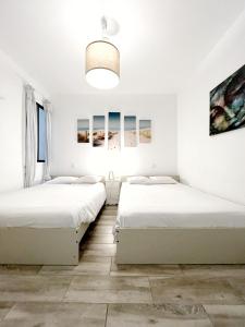 2 camas en una habitación con paredes blancas en 3 bedrooms with private parking By Canary365, en Las Palmas de Gran Canaria