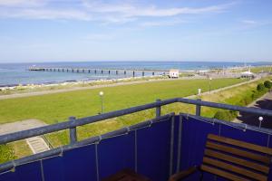 a blue fence with a bench and the ocean at Pier 33 in Schönberger Strand