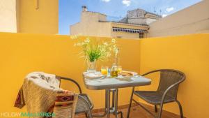 mesa pequeña con sillas y pared amarilla en Elegance Plaza Old Town, en Alcudia