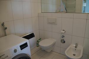 a small bathroom with a toilet and a sink at Pier 33 in Schönberger Strand +5 photos