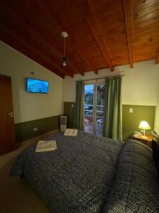 een slaapkamer met een bed en een tv aan de muur bij Don Hugo in Villa Giardino