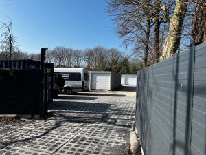 a parking lot with a fence and a trailer at Budget Flex in Geel