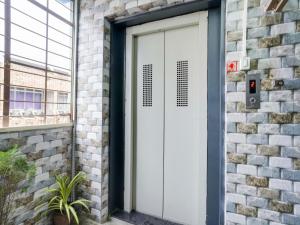 una porta bianca in garage su un edificio di mattoni di OYO Hotel Moon a Rajkot