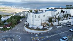 an aerial view of a white building next to the ocean at The Ivory Haus in Plettenberg Bay