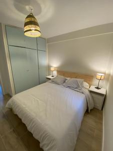 een slaapkamer met een groot wit bed met 2 lampen bij Precioso piso nuevo en 1ª línea pantano SJuan4P in San Martín de Valdeiglesias