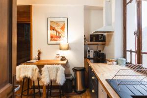 a kitchen with a table and stools in a room at Les Ruisseaux in Cauterets