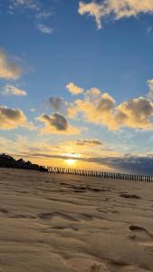 a view of the beach at sunset with a pier at les Calimottes in Sangatte