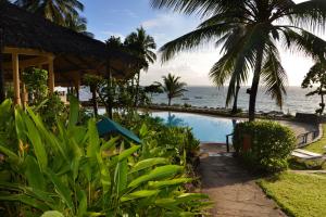 a beach with palm trees and palm trees at Baobab Beach Resort & Spa in Diani Beach