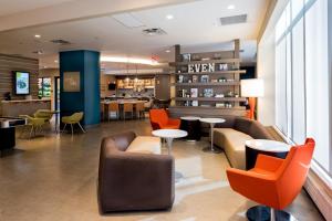 a lobby of a hotel with orange chairs and tables at EVEN Hotel Brooklyn, an IHG Hotel in Brooklyn