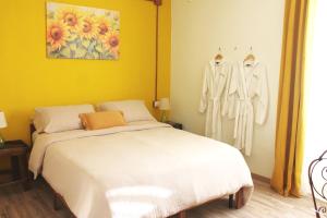 a bedroom with a white bed and clothes on hangers at Borgo del Canto in Borghetto dʼArroscia