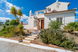 a white house with a palm tree in front of it at Rosana Lake Vinuela in Viñuela