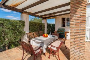 a table and chairs sitting on a patio at Rosana Lake Vinuela in Viñuela