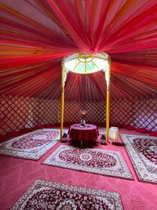 Habitación con mesa, cortinas rojas y alfombras en Lélek-Tér, en Siófok