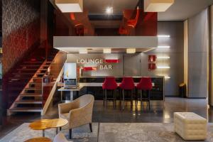a bar in a restaurant with red chairs and stairs at Eurostars Palazzo Zichy in Budapest