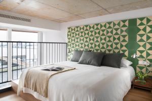 a bedroom with a white bed with a green wall at Eric Vökel Boutique Apartments - Riverfront Suites in Amsterdam