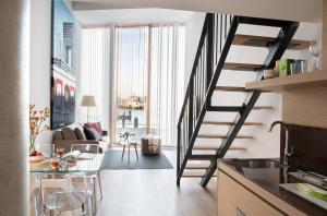 a kitchen and living room with a spiral staircase at Eric Vökel Boutique Apartments - Riverfront Suites in Amsterdam