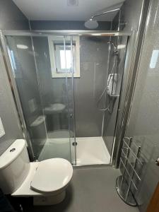 a bathroom with a toilet and a glass shower at The 1645 Inn in Nairn