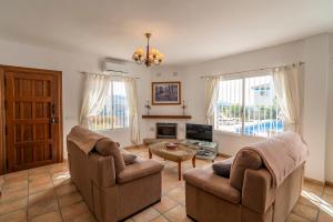 a living room with two chairs and a fireplace at Rosana Lake Vinuela in Viñuela