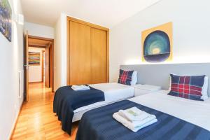 Habitación de hotel con 2 camas con sábanas azules y blancas en Vita Portucale ! Expo Deluxe with Terrace, en Lisboa