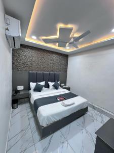 a bedroom with a bed with a ceiling fan at HOTEL THE PACIFIC in Ahmedabad