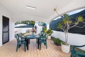 a patio with a table and chairs and a plant at Villa Luísa Galé in Albufeira