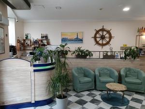 een wachtkamer met groene stoelen en een klok bij Hotel Galata in Genua