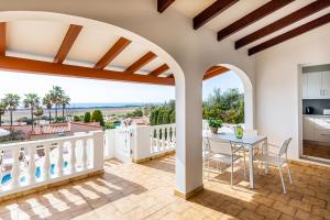 a kitchen and dining room with a balcony with a table at Villa Dreams in Son Bou