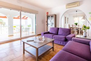 a living room with purple couches and a table at Villa Dreams in Son Bou