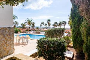 a villa with a swimming pool and palm trees at Villa Dreams in Son Bou