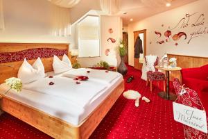 a bedroom with a large bed with a red carpet at Donauhotel Lettnerhof in Au an der Donau