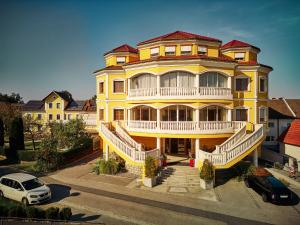 ein gelbes Haus mit einem weißen Auto, das davor geparkt ist. in der Unterkunft Donauhotel Lettnerhof in Au an der Donau