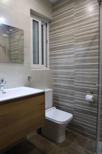 een badkamer met een toilet, een wastafel en een douche bij Spacious 3 bedroom apartment near bus terminus in St Paul's Bay