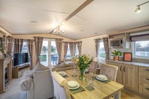 eine Küche und ein Wohnzimmer mit einem Tisch und Stühlen in der Unterkunft QUEEN V - Luxury Caravan - 2Bed - Seton Sands in Port Seton