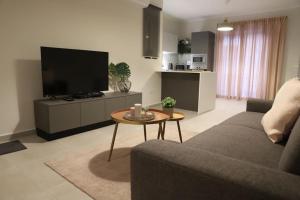 een woonkamer met een bank en een tafel met een tv bij Spacious 3 bedroom apartment near bus terminus in St Paul's Bay