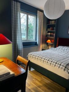 a bedroom with a bed and a table and a window at The cozy family Retreat Lübeck in Lübeck