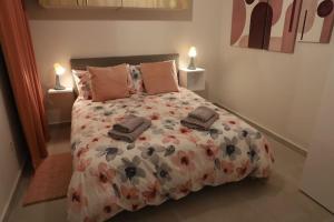 een slaapkamer met een groot bed met bloemen erop bij Spacious 3 bedroom apartment near bus terminus in St Paul's Bay