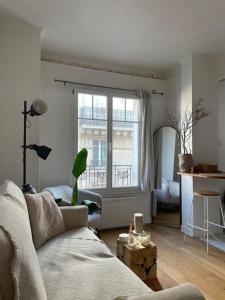 a living room with a couch and a window at Louis’ haven in Paris