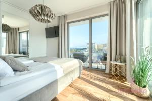 a bedroom with a large bed and a large window at Your Holidays Promenada Gwiazd 14 in Międzyzdroje