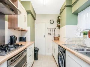 a kitchen with a sink and a dishwasher at Pass The Keys Basement Hideaway near Acton Main Line Your Peaceful Escape with London at Your Fingertips in London