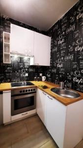 a kitchen with a black wall with drawings on it at Owsiana Zatoka in Rumia