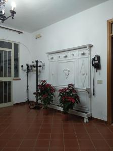 una stanza con due piante in vaso e un armadietto bianco di B&B vacanze Mille Colori a Cinisi