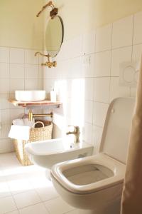 a white bathroom with a toilet and a sink at Borgo del Canto in Borghetto dʼArroscia