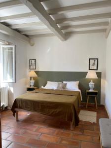 a bedroom with a large bed and two lamps at Lou Mas in Gordes