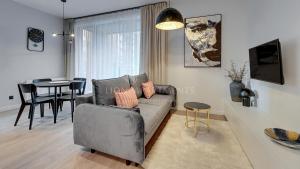 uma sala de estar com um sofá e uma mesa em Lion Apartments - SCALA City Center Premium Apartments ID em Gdansk