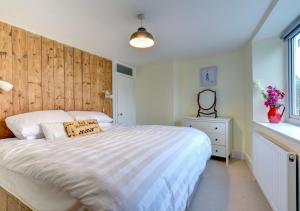a bedroom with a large bed with a wooden headboard at Meadow Cottage in Bridport