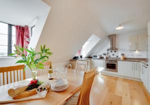 a kitchen and dining room with a wooden table and chairs at Flat 9 Broadleys in Swanage