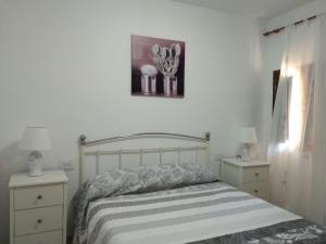 een slaapkamer met een bed met 2 nachtkastjes en 2 lampen bij Apartamento Paco 3 cerca de Valencia in Benafer